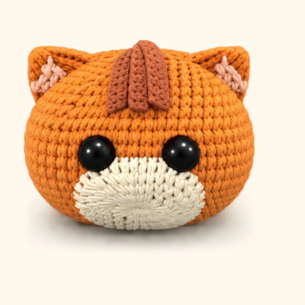 Orange tabby kitten crochet assembly: attach the forehead stripes